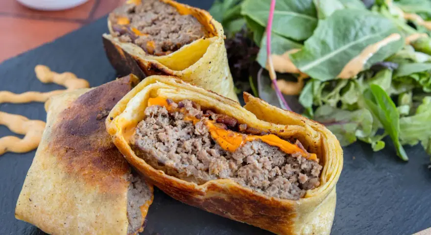 Herzhafte Burger Wraps mit geschmolzenem Käse und einem Beilagensalat.