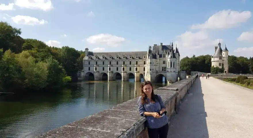 Kobieta na moście przed zamkiem Chenonceau, nad rzeką Cher, dopływem najdłuższej rzeki Francji, Loary.