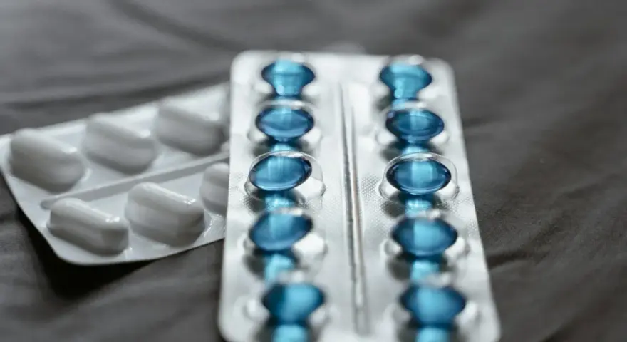 Dwa blistry leków: jeden z białymi kapsułkami, drugi z niebieskimi, które mogą być pregabalin accord.