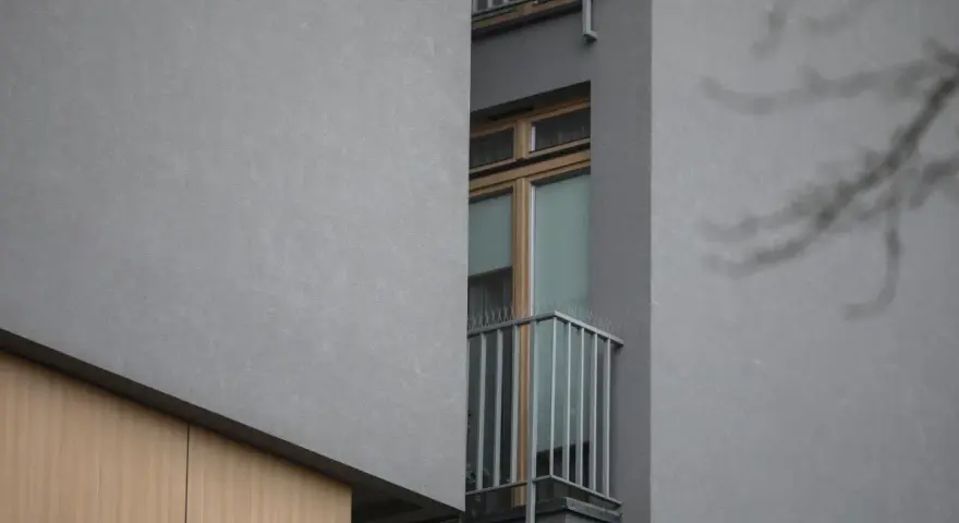 Szare ściany, drewniane elementy i wąskie okno z balkonem. To właśnie takie budynki budzą pytania, dlaczego mieszkańcy nowych osiedli masowo skarżą się na patodeweloperkę akustyczną.