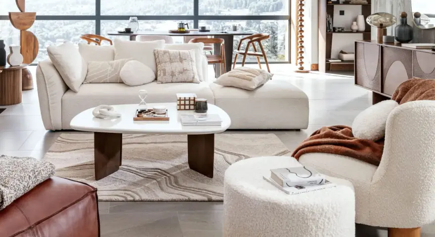 Un confortable salon d'hiver avec un canapé moelleux, une table basse design et une vue panoramique sur les montagnes enneigées.