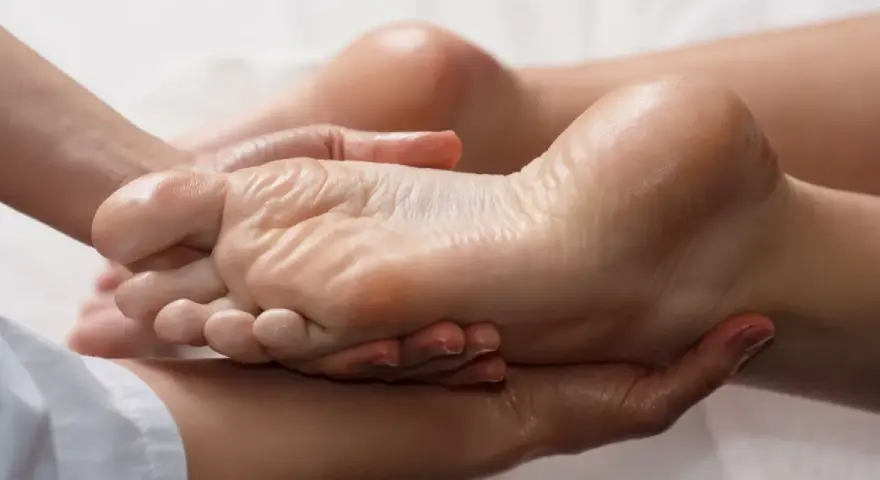 Mains expertes prodiguant un massage relaxant pour une manucure pied parfaite, hydratant et apaisant.