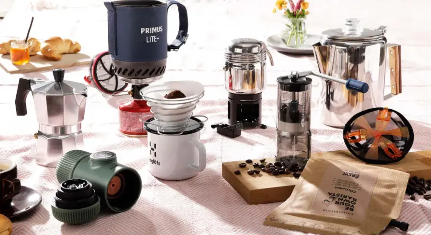 Perfekt für Kaffee kochen Camping: Mokkakanne, Filterkaffee-Set, French Press und Kaffeemühle auf einer Decke.