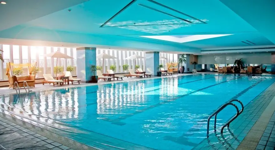 Relaks w hotelu z basenem na Podlasiu. Długi, błękitny basen z leżakami i parasolami, idealny na wakacje.