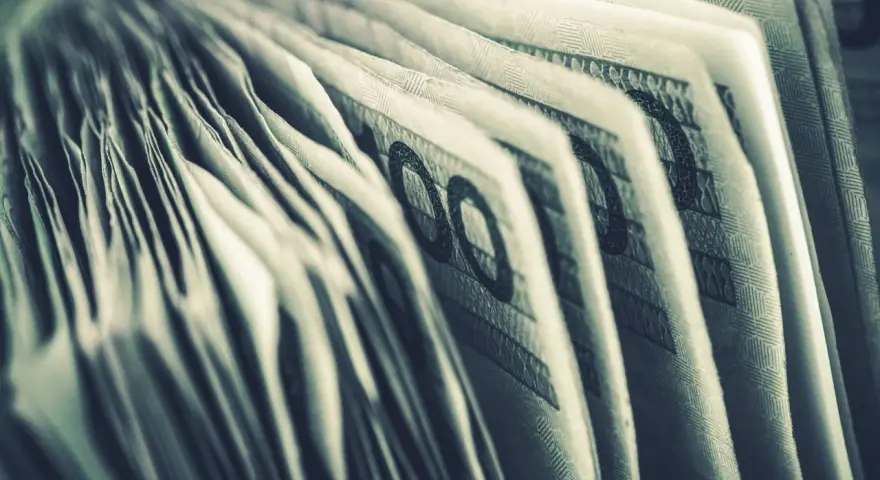 Zbliżenie na banknoty 100 zł. Widoczne detale i wzory, sugerujące zgromadzone środki, być może jako konto depozytowe osadzonego.