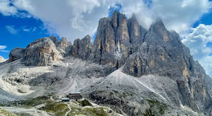 Rifugio alpino ai piedi di imponenti vette dolomitiche, ideale per un trekking di 5 giorni.