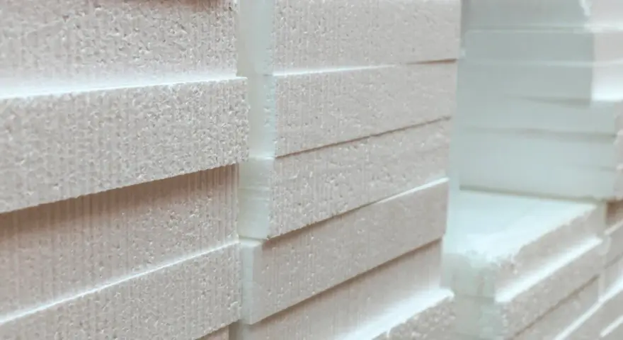 Stos płyt styropianowych, idealnych na mur 40 cm. Grubość i struktura materiału sugerują doskonałą izolację termiczną.
