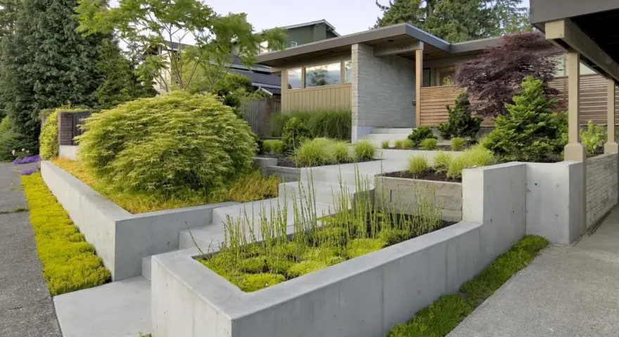 Modern entré inspiration utomhus med betongmurar, trappor och frodig grönska. En inbjudande och stilren design.