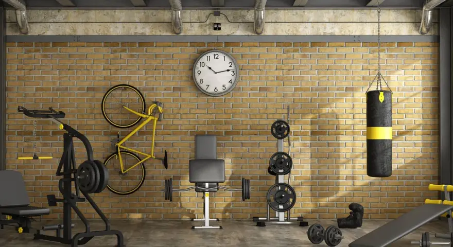 Ett välutrustat gym i garaget med vikter, boxningssäck, cykel och träningsbänk.