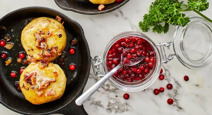 Kroppkakor recept: Gyllene kroppkakor i gjutjärnspanna med knaperstekt fläsk och lingonsylt. En klassisk svensk rätt.
