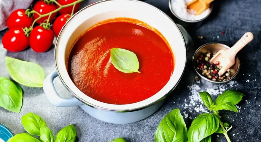 Frische Tomaten, Basilikum und Gewürze – alles bereit, um tomatensauce selber machen. Ein Genuss!