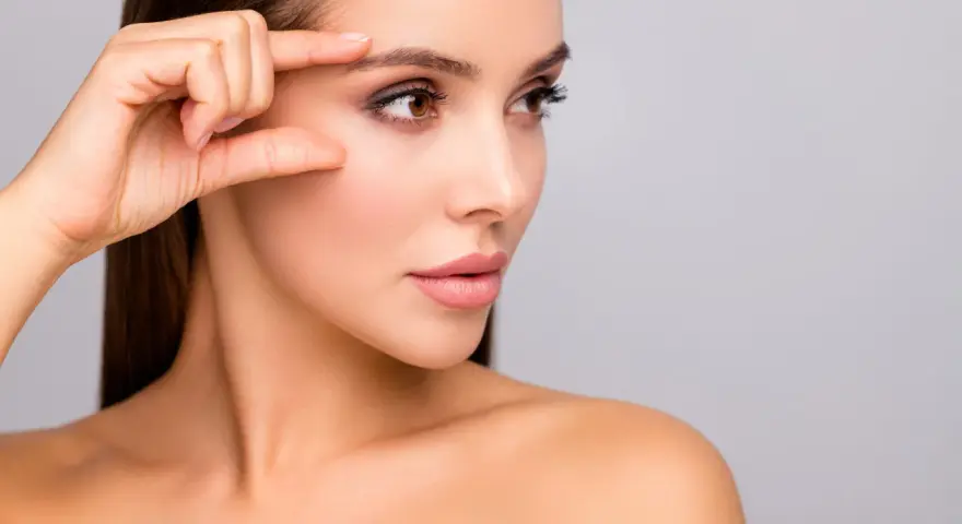 Kobieta bada swoją skórę, która po zabiegu skin booster jest nawilżona i promienna.