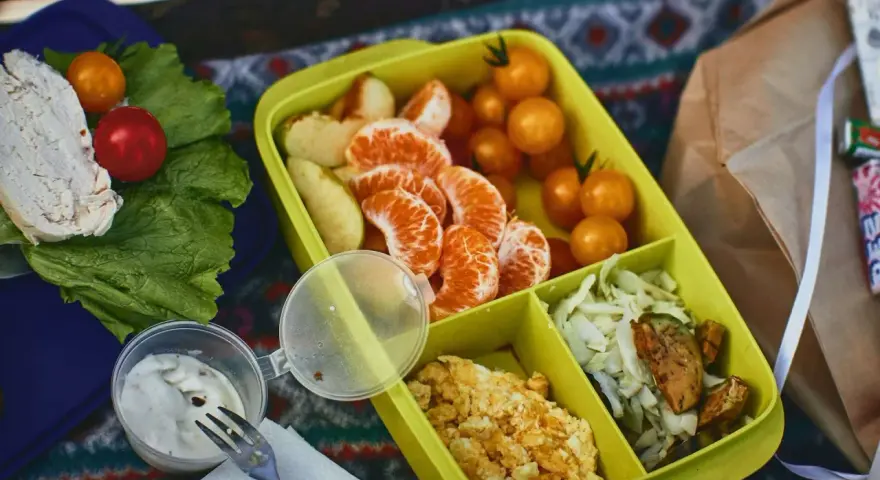Piknikowy lunch: kurczak, pomidorki, mandarynki, jajecznica i surówka. Czy można wziąć jedzenie do samolotu Ryanair? Takie posiłki są idealne na podróż.