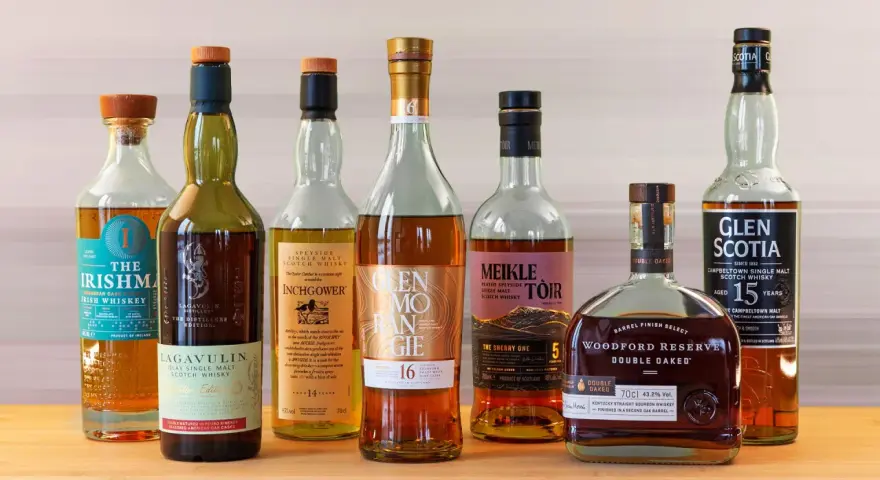 Eine Auswahl von sieben Flaschen, darunter Irish Whiskey und Scotch, die zu den top 10 besten Whisky zählen könnten.