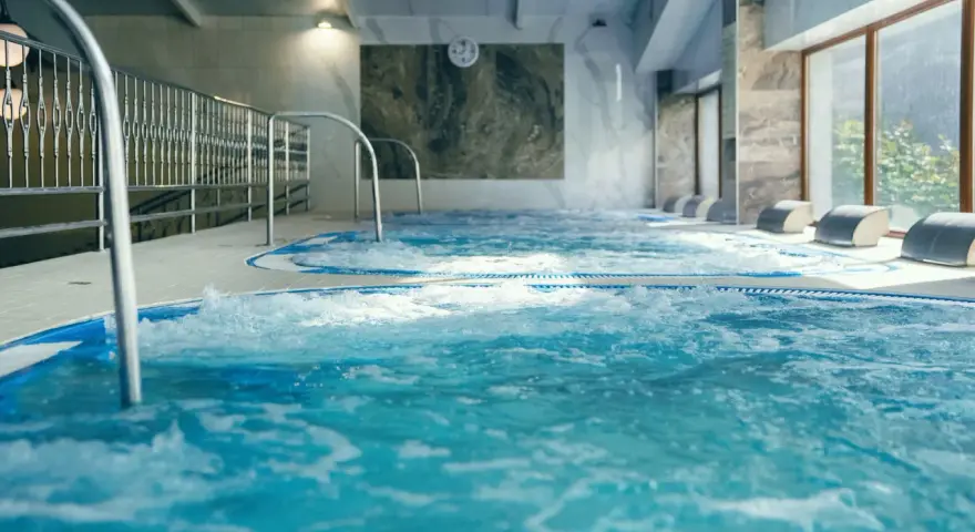 Relaks w hotelu z basenem w Białymstoku. Bąbelki unoszą się w wodzie jacuzzi, zapraszając do odpoczynku.