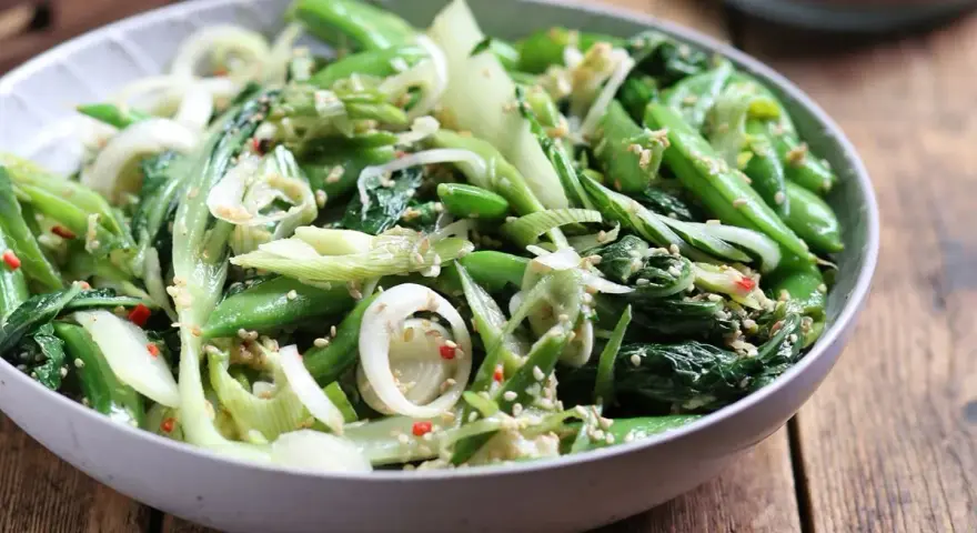 Zielona sałatka z pak choi, groszku cukrowego i cebuli, posypana sezamem. Idealna do dań kuchni azjatyckiej, świetne kapusta pak choi przepisy.
