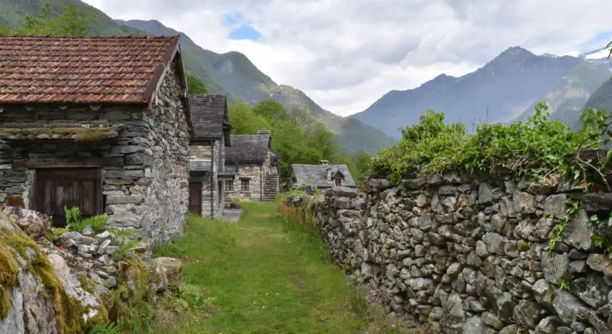 Steindörfer im Valle Maggia, umgeben von grünen Bergen und bewachsenen Mauern.