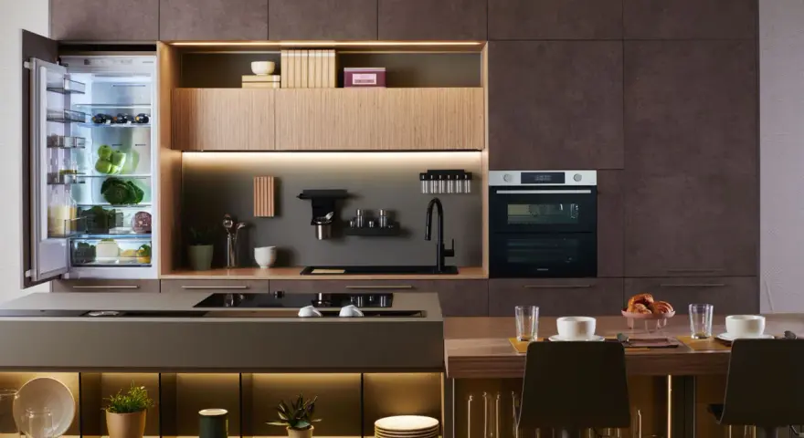 Cuisine moderne avec réfrigérateur ouvert, montrant des aliments frais. Le réfrigérateur est de taille frigo standard, intégré dans des meubles élégants.