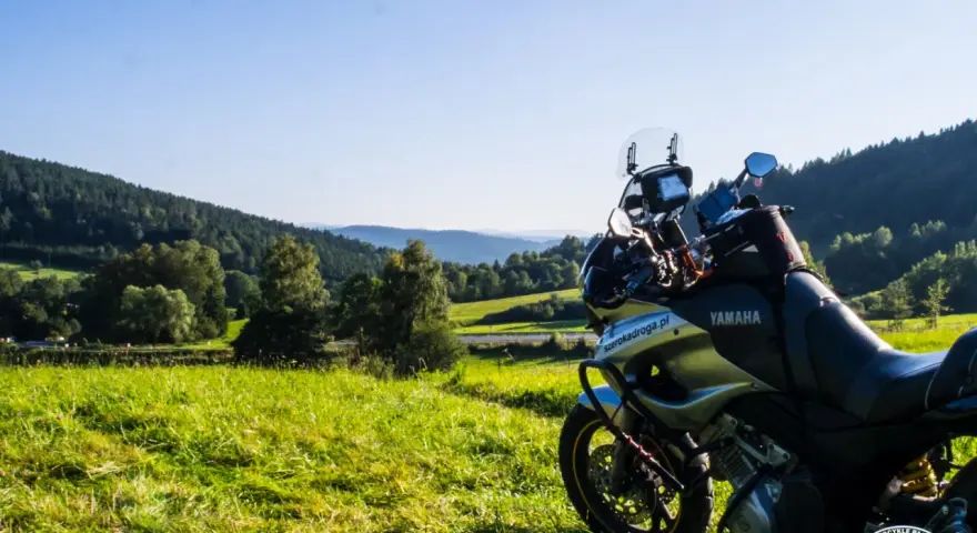 Motocykl Yamaha zaparkowany na łące, w tle malownicze wzgórza Bieszczad. Idealne miejsce na przejażdżkę pętlą bieszczadzką.