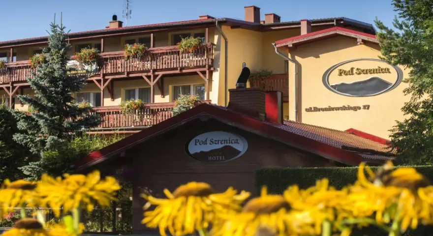 Hotel Pod Szrenicą w Szklarskiej Porębie, otoczony zielenią i kwitnącymi kwiatami, zaprasza na wypoczynek.