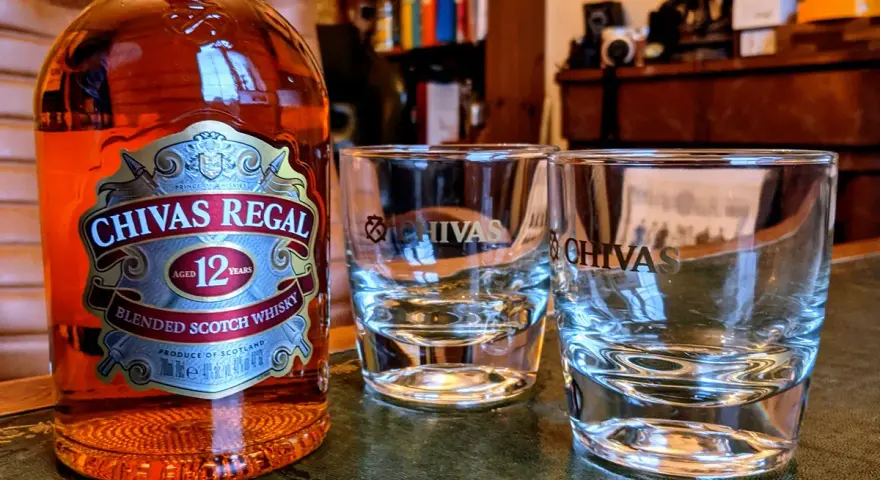 Chivas Regal 12 z czym pić? Butelka Chivas Regal 12 i dwa kieliszki, gotowe na degustację.