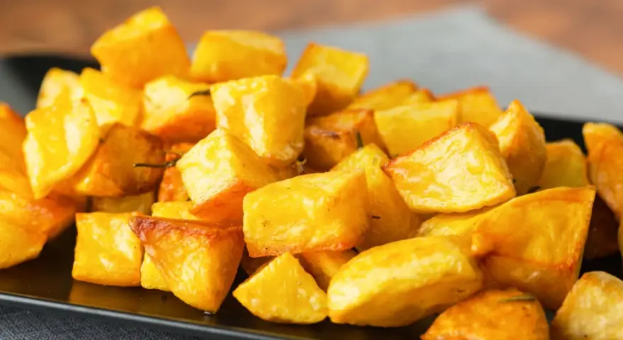 Un mucchio invitante di patate al forno croccanti, dorate e profumate, pronte per essere gustate.