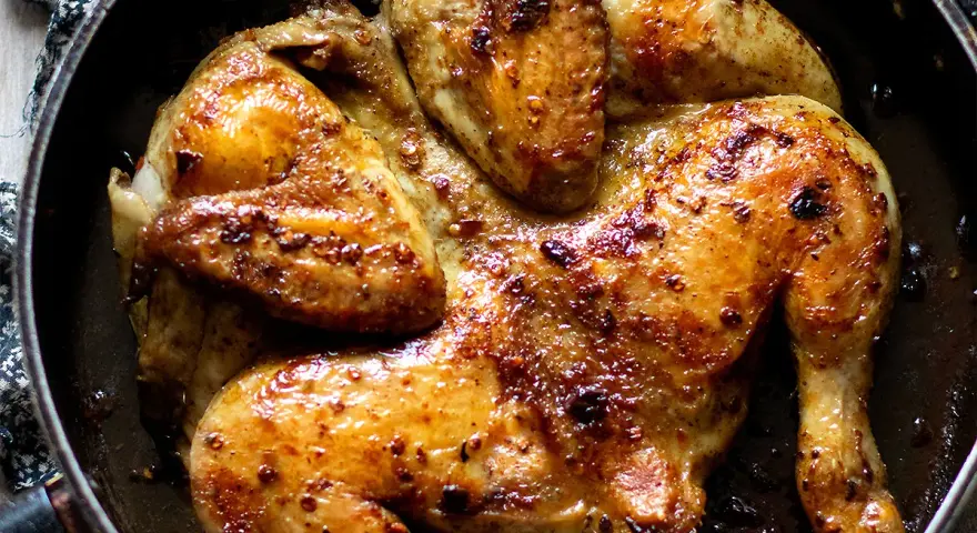 Pollo alla diavola dorato e succulento, cotto in padella con spezie piccanti.
