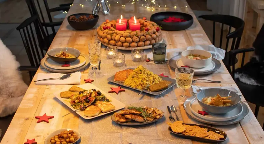 Festlich gedeckter Tisch mit leckerem Essen, bereit für das weihnachtsessen einen tag vorher vorbereiten. Kerzen brennen, Nüsse und Tannenzapfen schmücken.