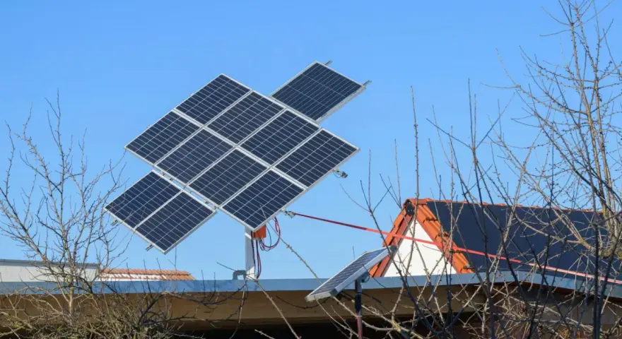 System paneli fotowoltaicznych z trackerem PV, zamontowany na dachu domu, na tle błękitnego nieba.