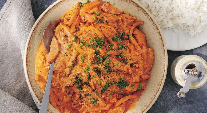 En krämig korvgryta, perfekt för ett snabbt och gott korvgryta recept. Serveras med fluffigt ris och toppas med färsk persilja.