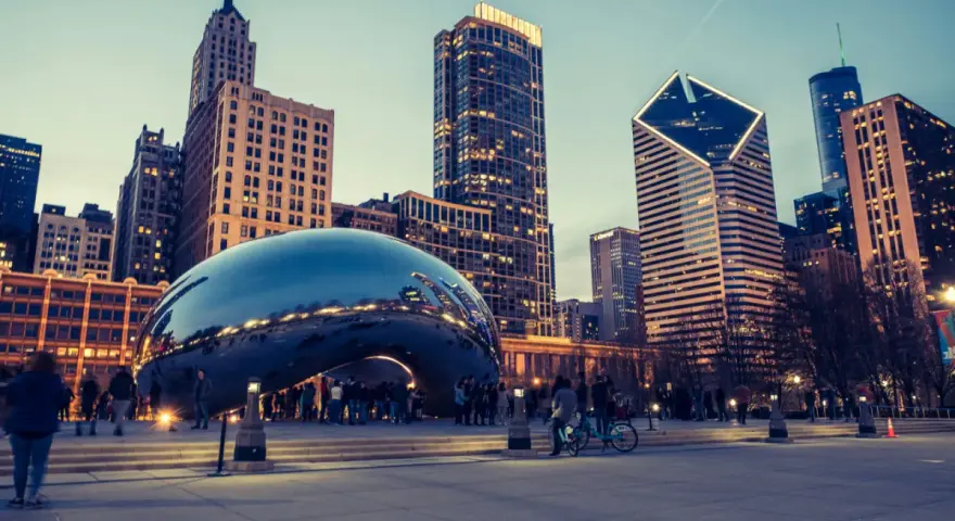 Reflections of the Chicago skyline shimmer on the iconic Cloud Gate sculpture. A perfect snapshot of Chicago in a day, with people enjoying the evening.