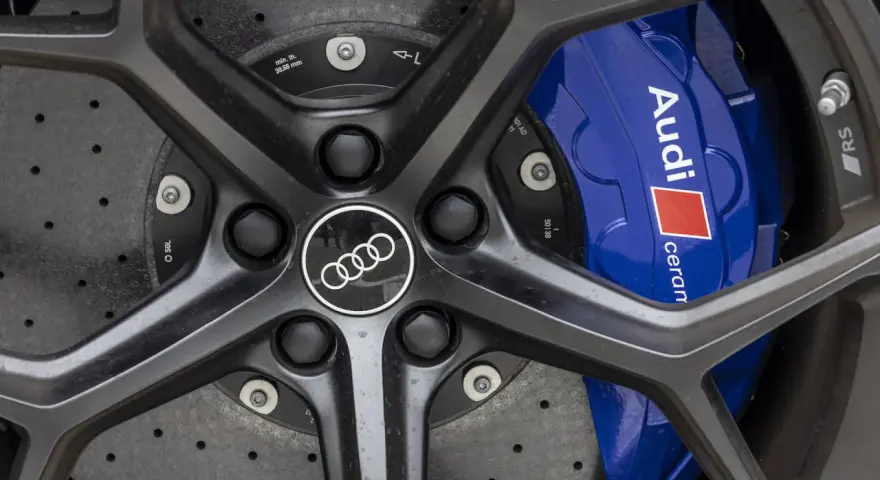 Primo piano di un cerchio Audi RS6 con pinze freno blu e logo Audi.