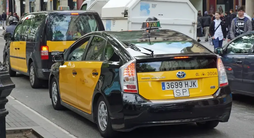 Gelbe Taxis in Barcelona, ein Toyota Prius und ein größeres Taxi XL, warten auf Fahrgäste.