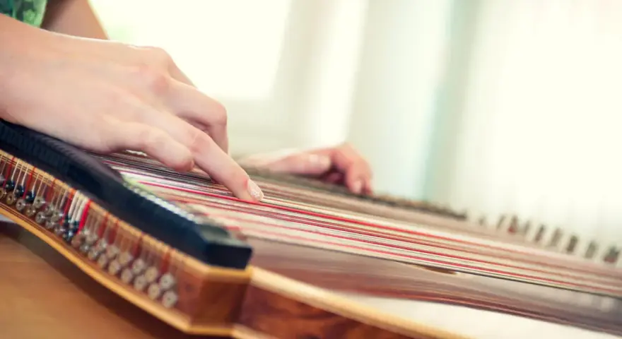 Hände spielen auf einem Hackbrett, das vielleicht das einfachste Instrument ist, um Melodien zu erzeugen.