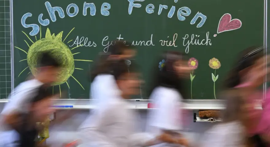 Schöne Ferien! Kinder freuen sich auf die Osterferien 2026 in NRW. Die Tafel zeigt Sonne, Blumen und ein Herz.