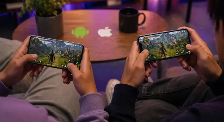 Dos personas juegan en sus teléfonos, inmersas en uno de los mejores RPG. El logo de Android y Apple en la mesa sugieren que la aventura está disponible para todos.