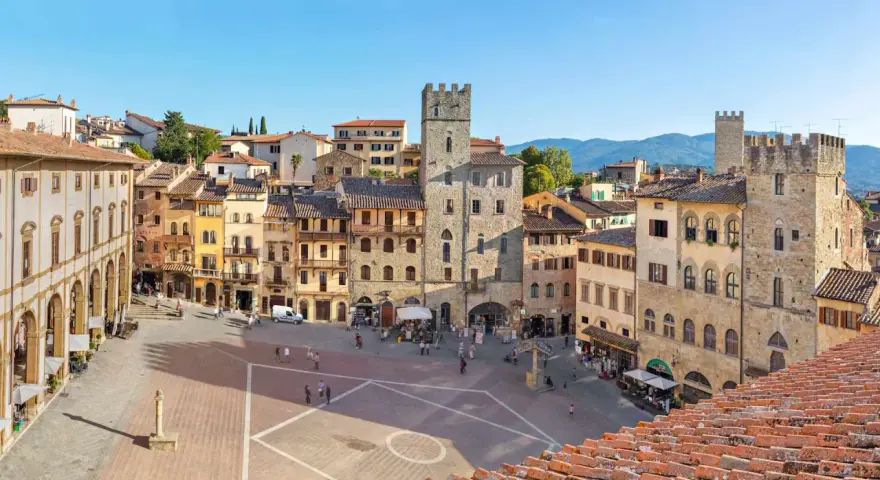 Piazza del Popolo ad Arezzo, con la torre medievale e i palazzi storici che incorniciano la piazza, un luogo incantevole nei dintorni.