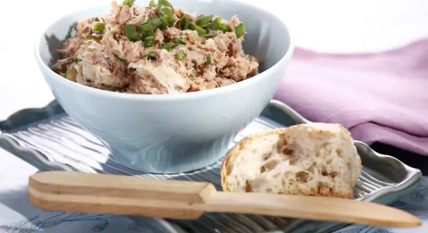 Pyszna pasta z tuńczyka i jajka, posypana szczypiorkiem, podana z kawałkiem chleba. Idealna na szybką przekąskę.