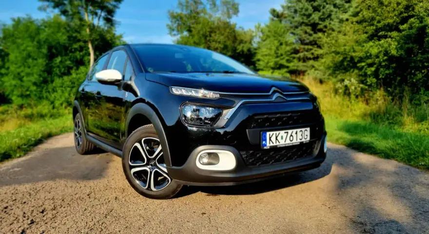 Czarny Citroen C3 na tle zieleni. Sprawdź atrakcyjną citroen c3 cena i wybierz swój wymarzony samochód.