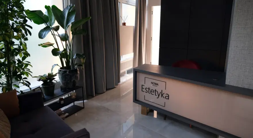 Nowa estetyka Wrocław: nowoczesne wnętrze salonu piękności z roślinami i wygodną sofą.