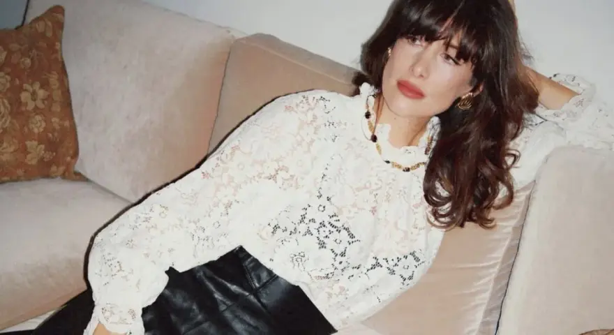 Kobieta w koronkowej bluzce i skórzanych spodniach, uosobienie stylu boho stylizacje.