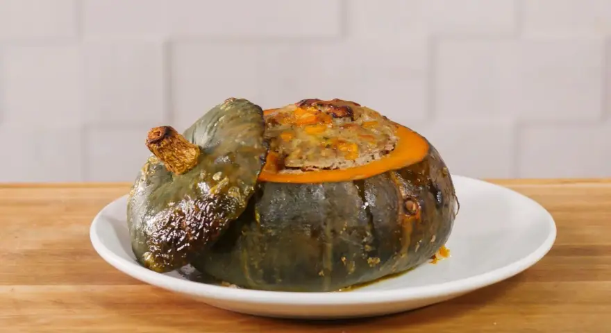 Deliziosa zucca ripiena, con un appetitoso ripieno dorato che fuoriesce dal suo guscio cotto.
