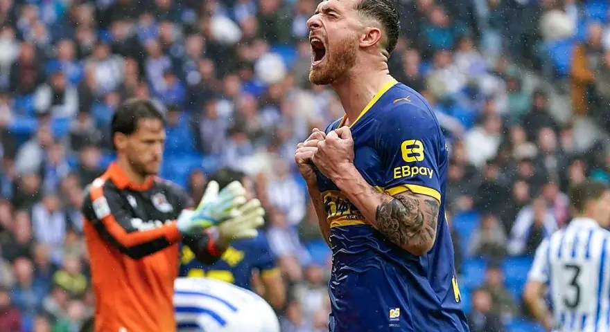Jugador del Alavés celebra eufórico un gol contra la Real Sociedad. El portero observa con resignación.