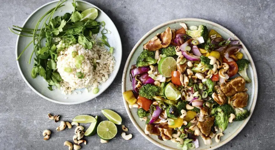En färgstark wok med kyckling, grönsaker och cashewnötter, serverad med ris. Perfekt middagstips helg!