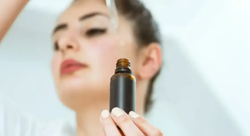 Kobieta aplikuje serum na twarz. Odkryj zachwycające ozonowanie twarzy efekty dla promiennej cery.