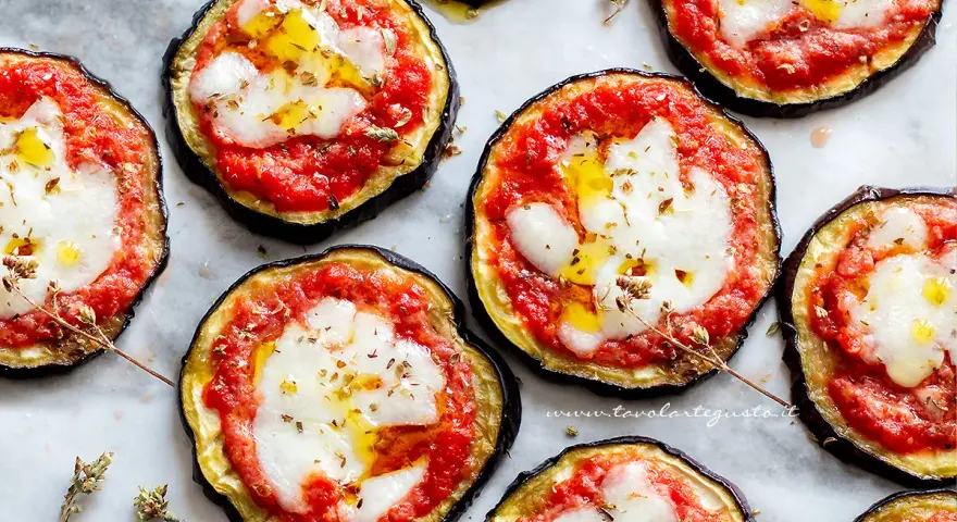 Pizzette di melanzane, gustose e colorate, con pomodoro, mozzarella filante e un filo d'olio.