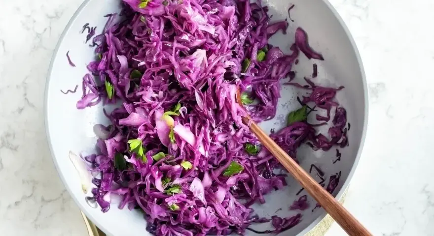 Insalata fresca e colorata di cavolo cappuccio rosso, condita con erbe aromatiche, pronta per essere gustata.