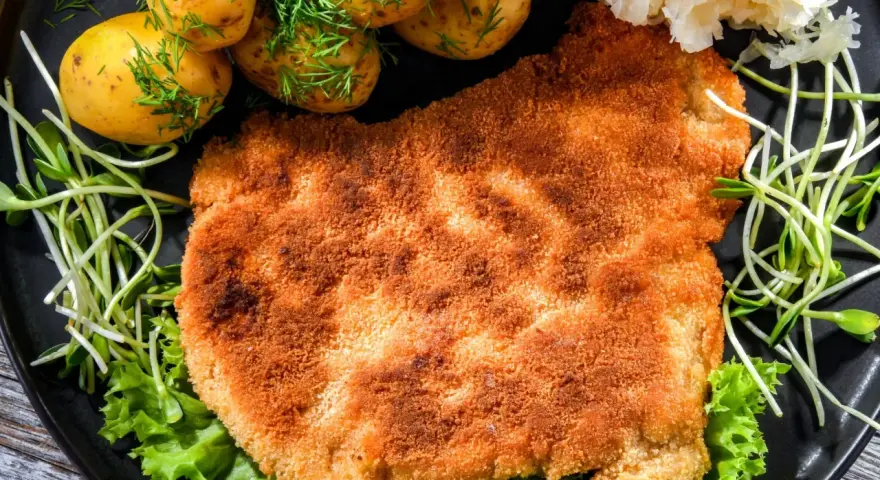 Chrupiący schabowy w panko, podany z młodymi ziemniaczkami, surówką i kiełkami. Pyszny obiad gotowy!
