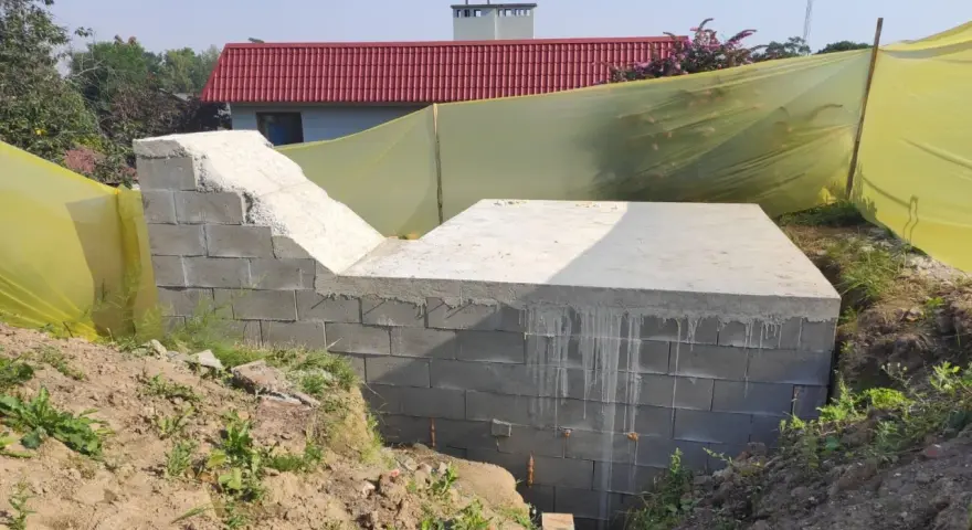 Budowa ziemianki: betonowy fundament i ściany z bloczków, gotowe do dalszych prac.