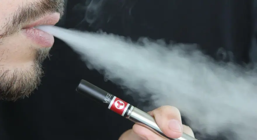 Hombre vapeando con un dispositivo Vuse, exhalando vapor. Una opción para quienes buscan vapers sin nicotina y cuidan su salud.